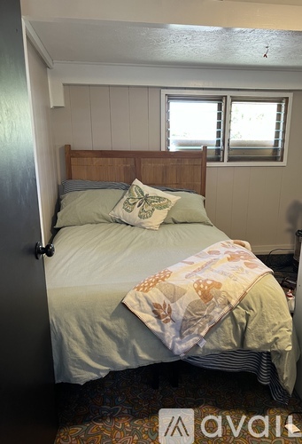 A bedroom with a bed, pillow, and a window.