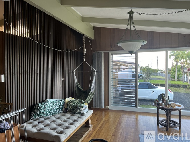 A living room with a hammock hanging from the ceiling.