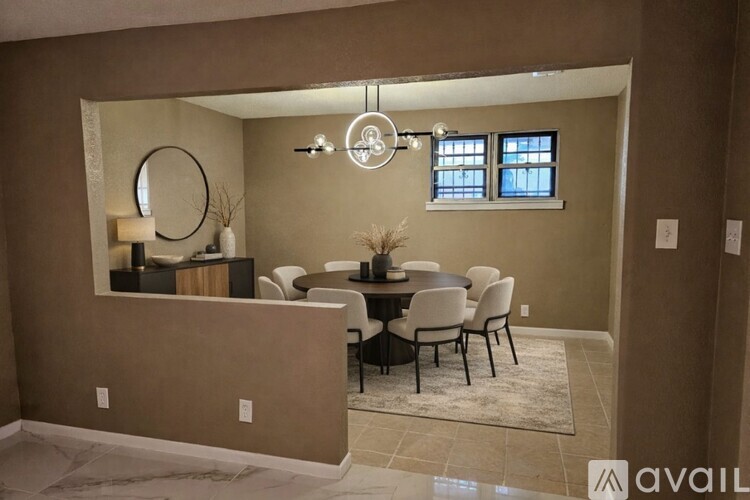 A dining room with a round mirror and a chandelier.