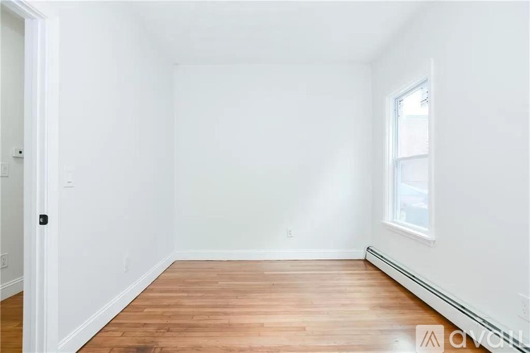 A room with wooden flooring and a window.