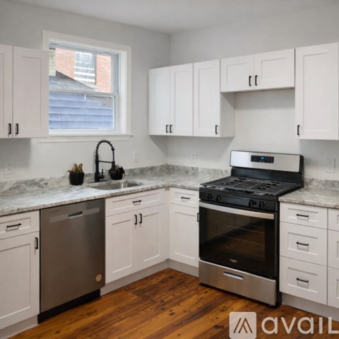 A kitchen with white cabinets and a black stove top oven.