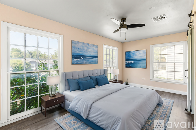 A bedroom with a large bed and a ceiling fan.