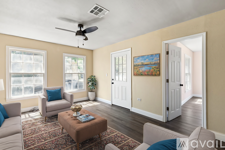 A living room with a ceiling fan, two chairs, a couch, and a coffee table.