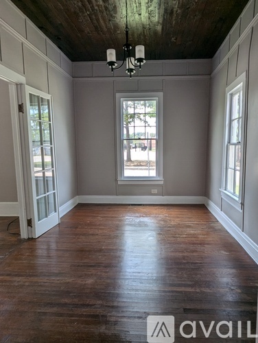 A room with wooden floors and a chandelier.
