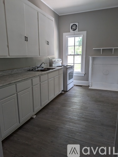 A kitchen with white cabinets and a window.
