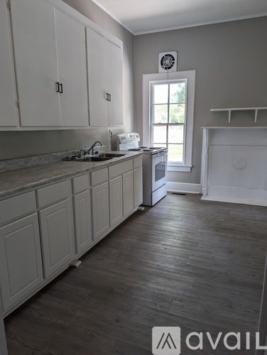 A kitchen with white cabinets and a window.