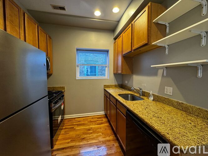 A kitchen with wooden cabinets and a granite countertop.