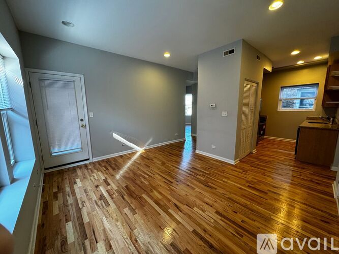 A room with wooden flooring and a white door.