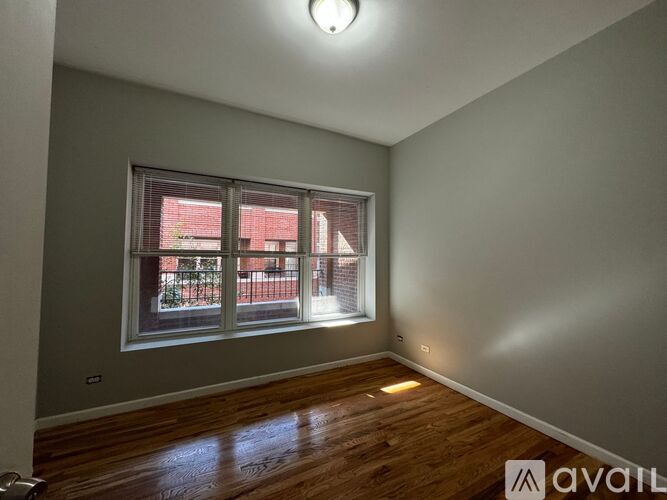 A room with a large window and wooden flooring.