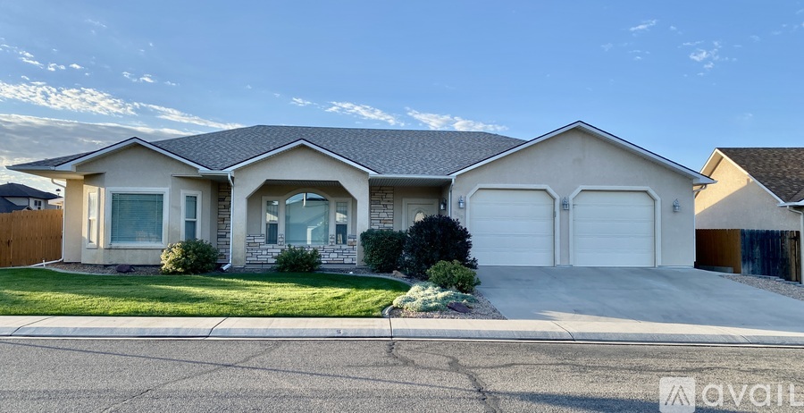 A house with a garage and a driveway in front of it.