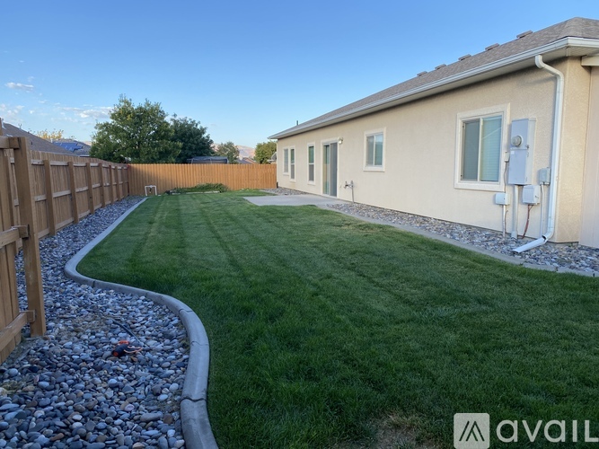 A house with a well-maintained lawn and a gravel pathway in front.