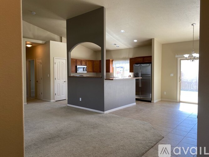 A spacious living area with a kitchen in the background.