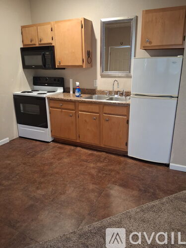 A kitchen with brown cabinets and a white fridge.