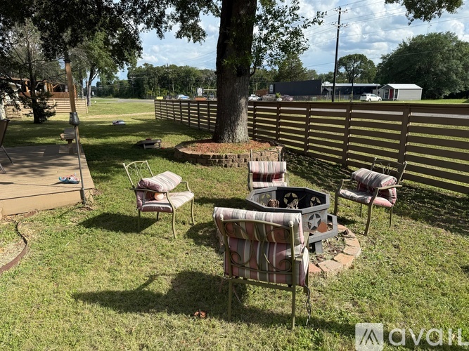 A backyard with a fire pit and chairs.