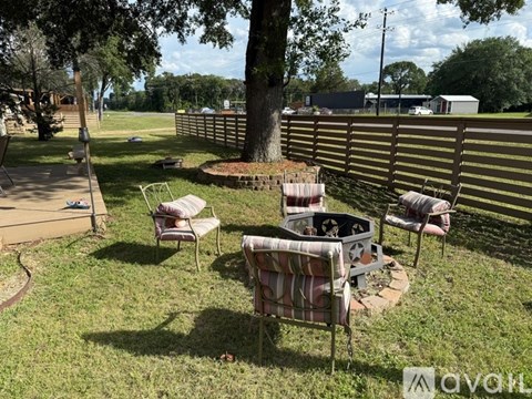 A backyard with a fire pit and chairs.