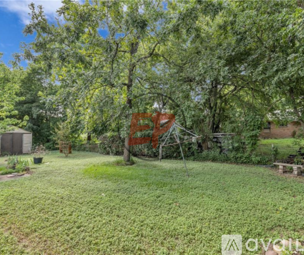A backyard with a swing set and trees.