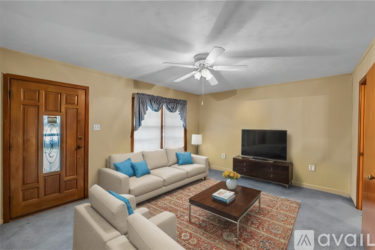 A living room with a beige couch, a coffee table, and a flat screen TV.