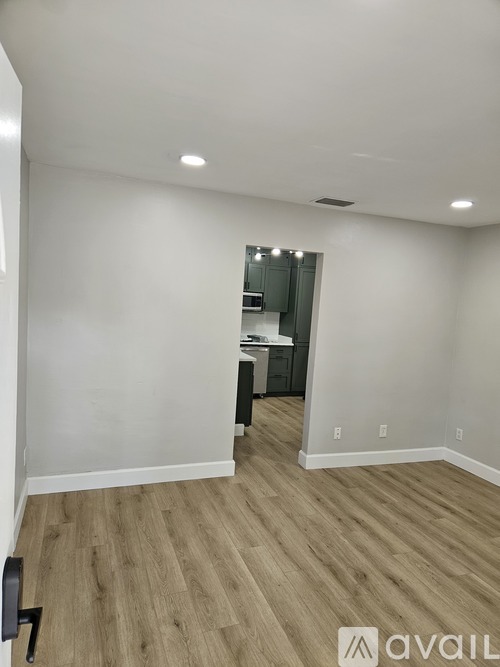 A room with wooden flooring and white walls.