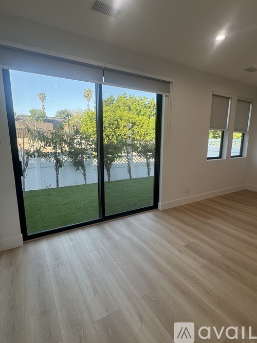 A room with a sliding glass door leading to a backyard.