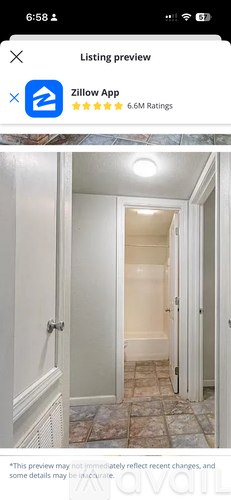 A hallway with a tiled floor and white walls.