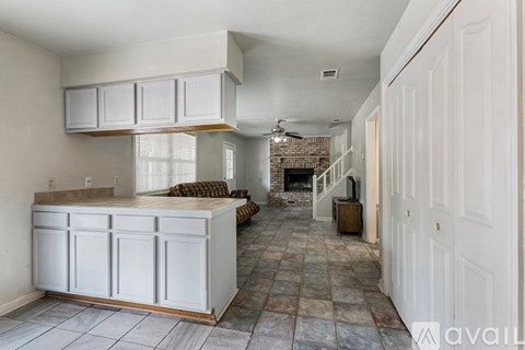 A kitchen with white cabinets and a tiled floor.