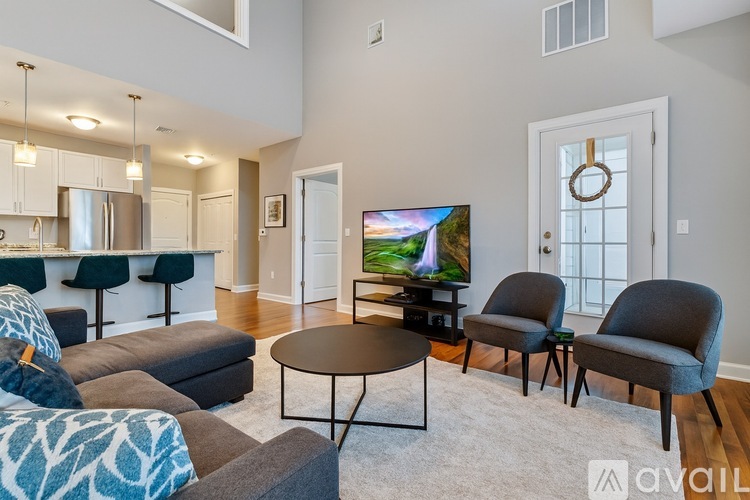 A living room with a television and two chairs.