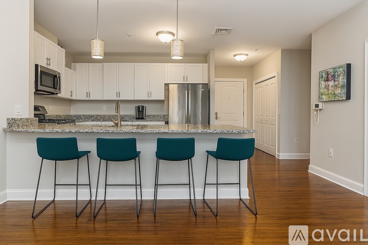 A kitchen with a bar stool in front of the counter.