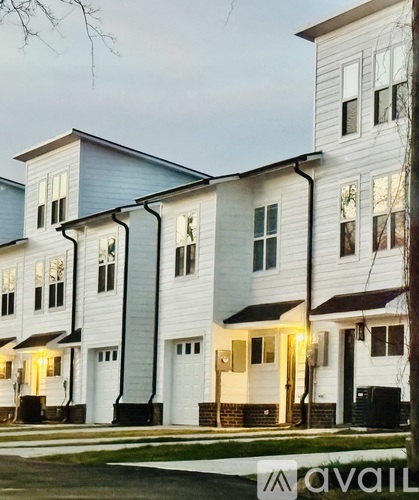 A row of modern townhouses with white and blue exteriors.