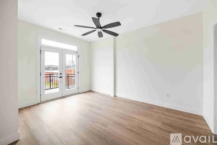 A room with a ceiling fan and a sliding glass door leading outside.