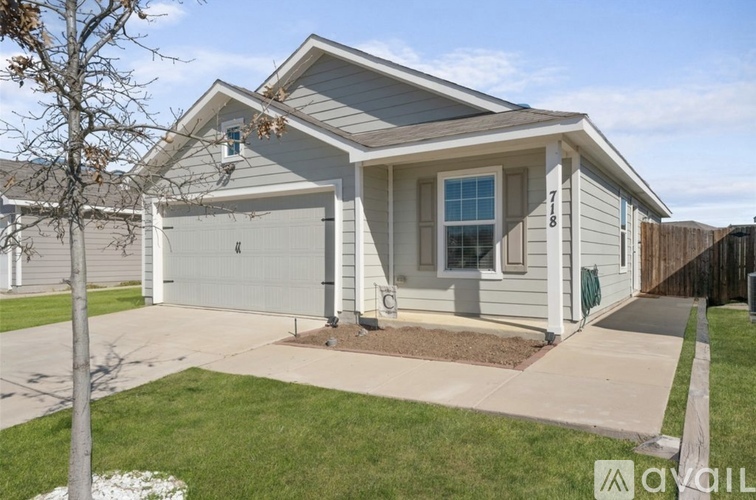 A house with a grey garage door and a white window.