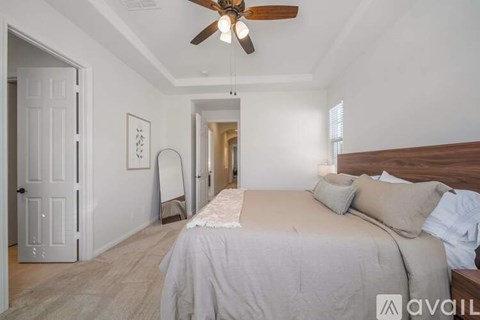 A bedroom with a large bed and a ceiling fan.