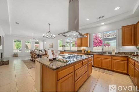 A kitchen with wooden cabinets and a granite countertop.