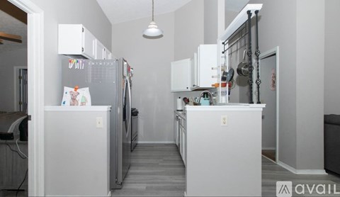 A kitchen with white appliances and cabinets.