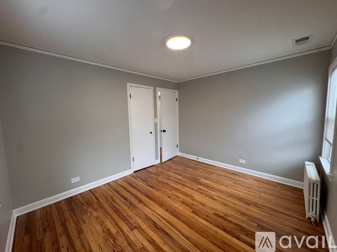 A room with wooden floors and two white doors.