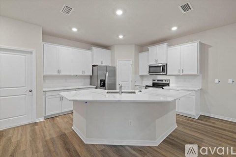 A kitchen with white cabinets and a large island.