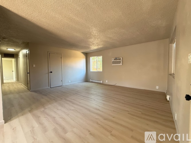A room with wooden flooring and a window on the wall.