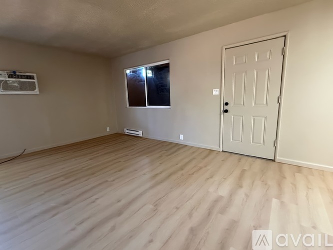 A room with a white door and a window with blinds.