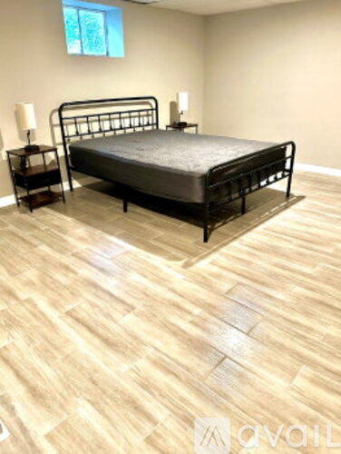 A bedroom with a bed, nightstands, and a window.