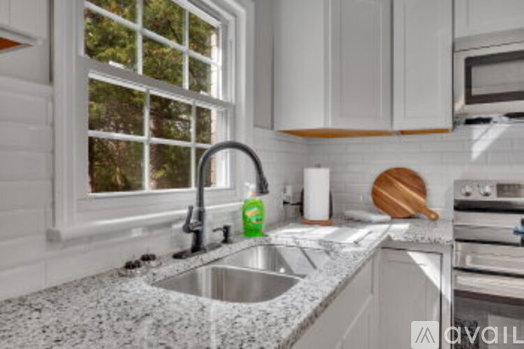 A kitchen with a granite countertop and stainless steel appliances.