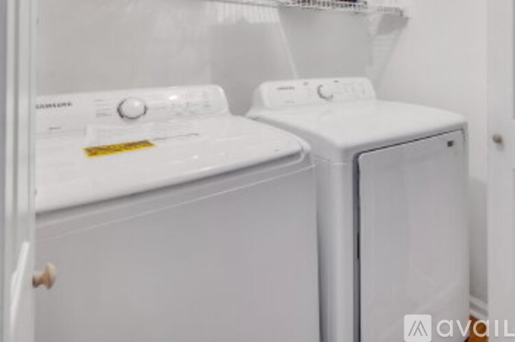 Two white front loading washing machines in a small laundry room.