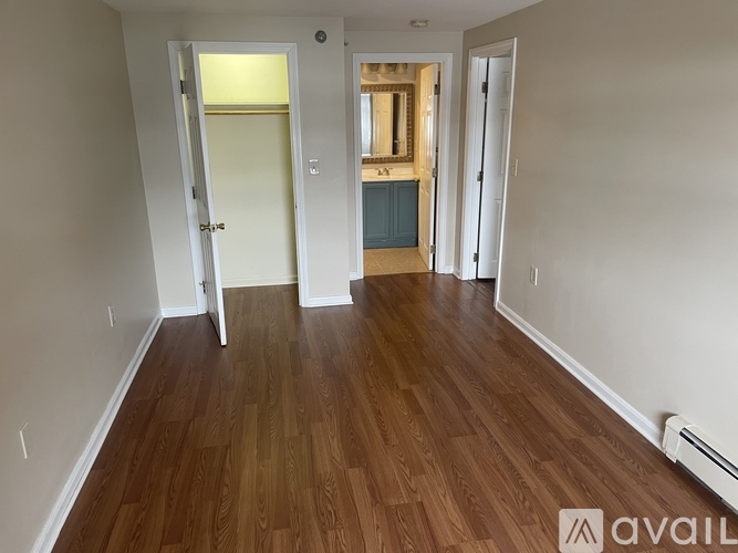 A room with wooden flooring and white walls.