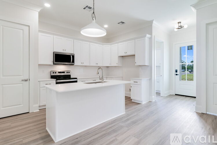 A modern kitchen with white cabinets and a central island.