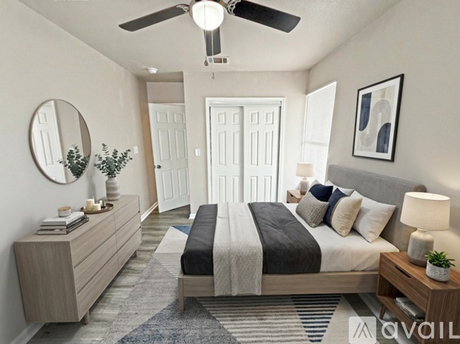 A well-lit bedroom with a large bed and a mirror on the wall.