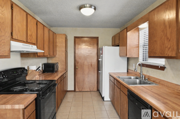 A kitchen with wooden cabinets and black appliances.