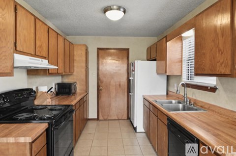 A kitchen with wooden cabinets and black appliances.