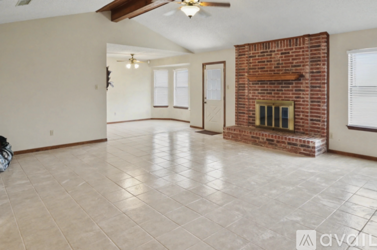A living room with a fireplace and a ceiling fan.
