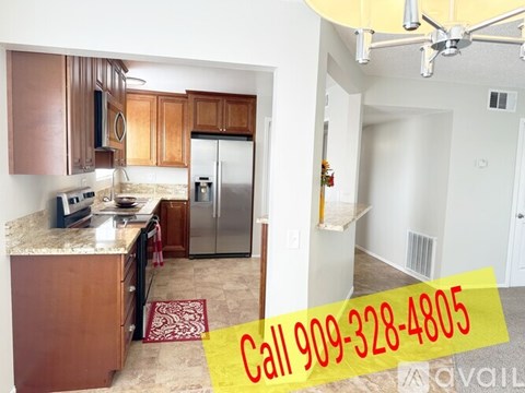 A kitchen with a refrigerator, microwave, and oven, and a living room with a couch and a coffee table.