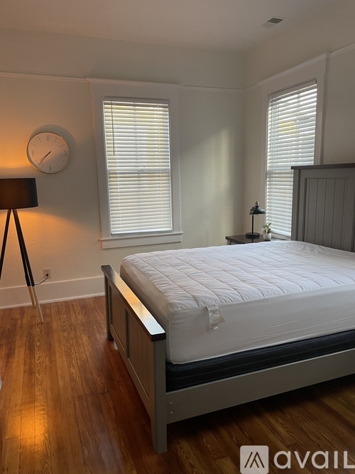 A bedroom with a large bed and a clock on the wall.