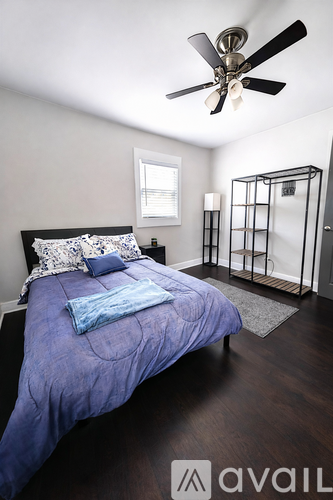 A bedroom with a bed, a ceiling fan, and a walk-in closet.