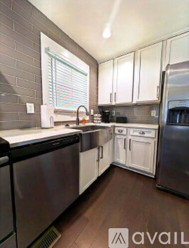 A kitchen with white cabinets and stainless steel appliances.